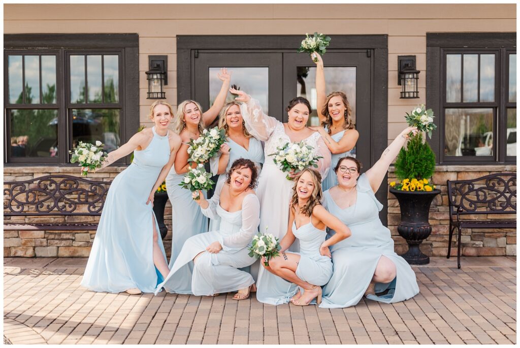 bridal party and bride using a fun pose at front of venue in Virginia 