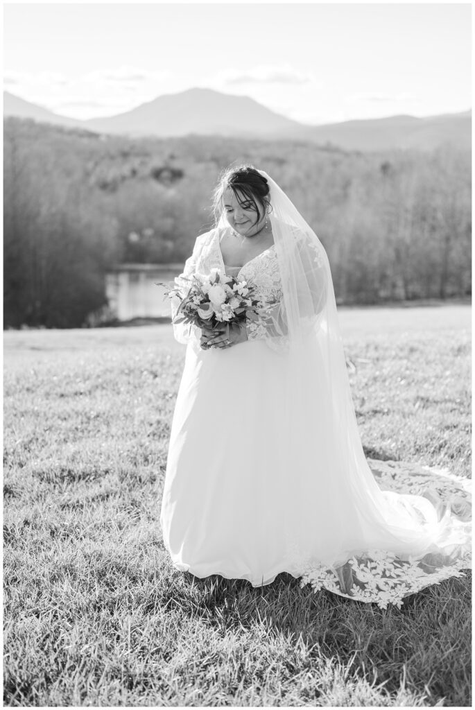 bride looking down at her bouquet with the Virginia mountains in the background 