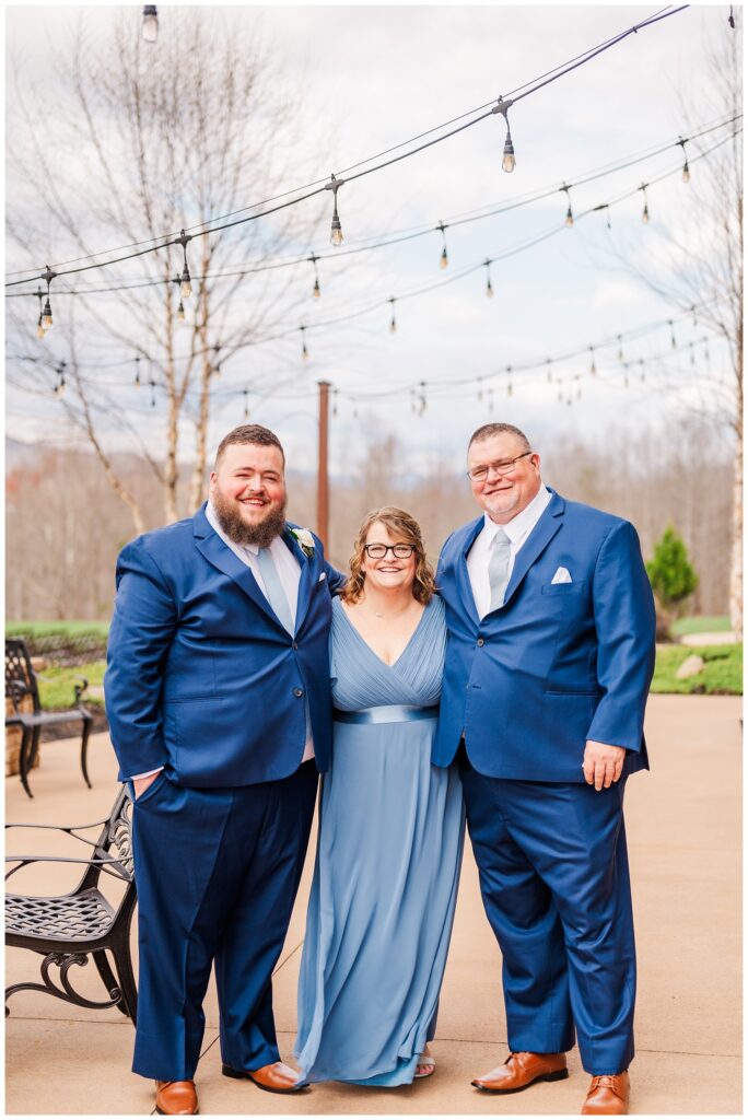 groom posing with his parents before the ceremony at the Glass Hill Venue