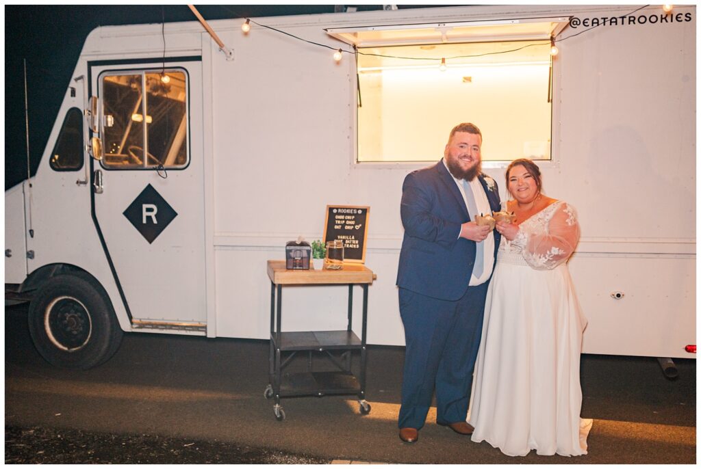 wedding couple eating ice cream in front of the truck at their reception