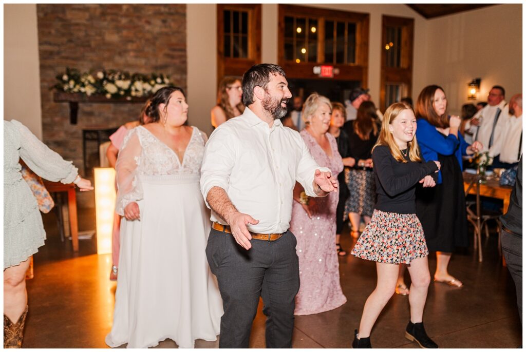 wedding reception guests dancing with the bride and groom at Glass Hill Venue