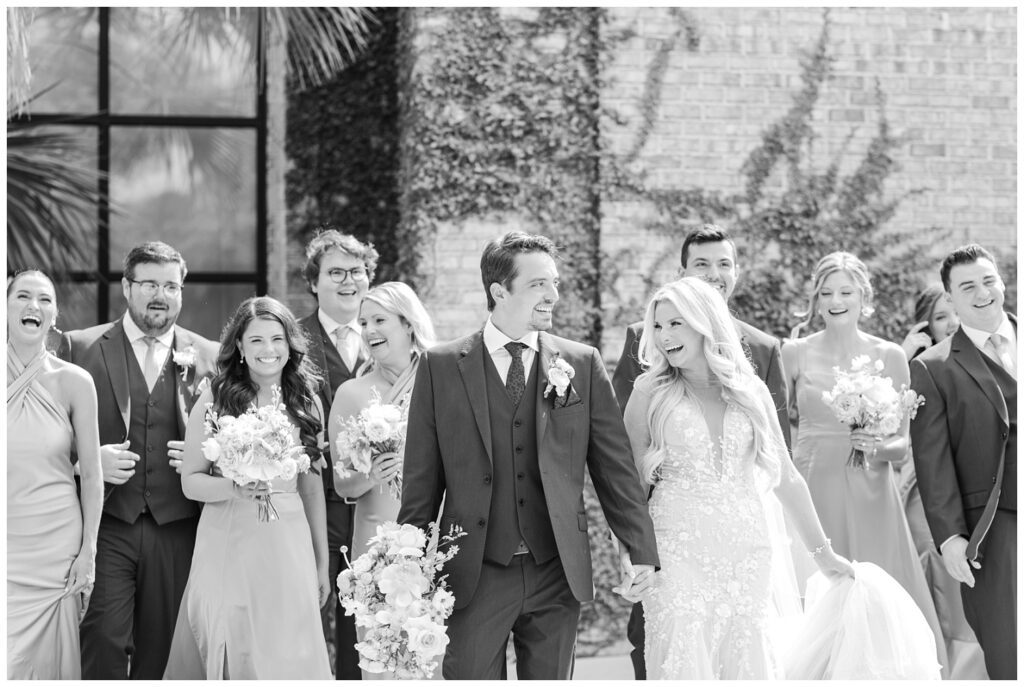 full wedding party walking outside in front of Wrightsville Manor in Wilmington