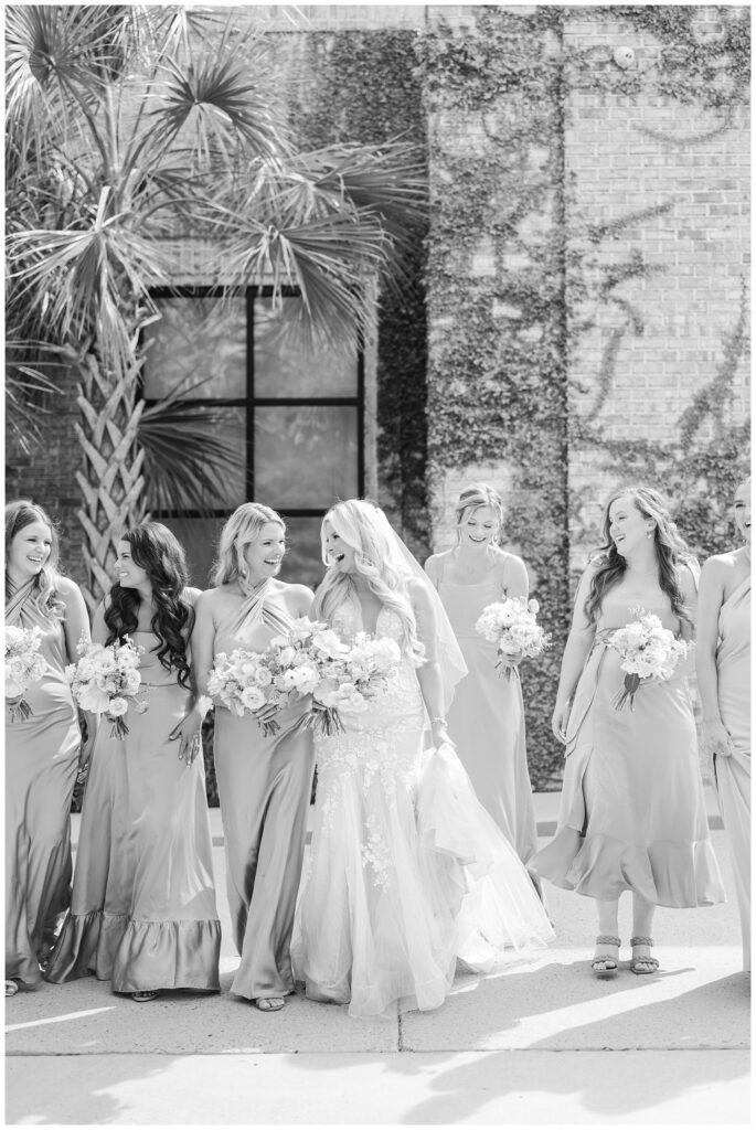 bride walking and laughing with her bridesmaids at Wilmington spring wedding