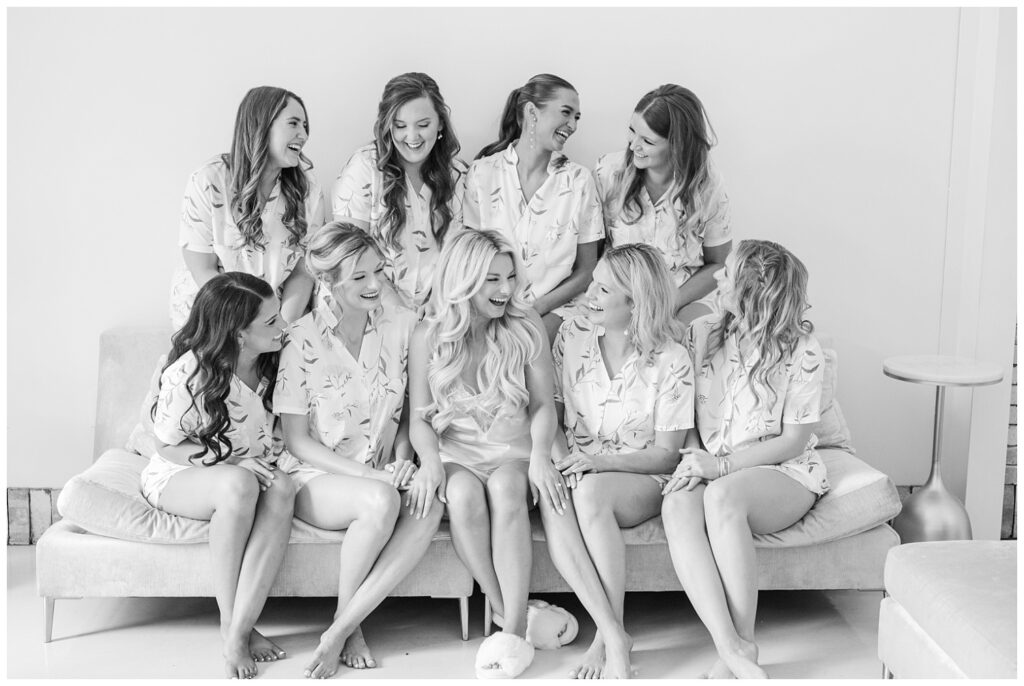 bride posing with her bridesmaids in matching pajamas on a couch