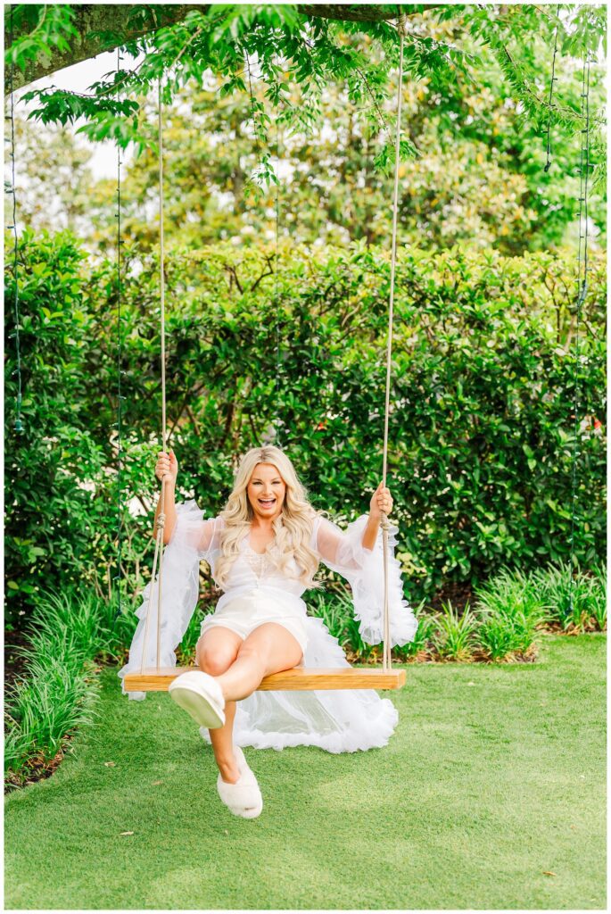 bride outside on a large swing wearing a white lingerie outfit 