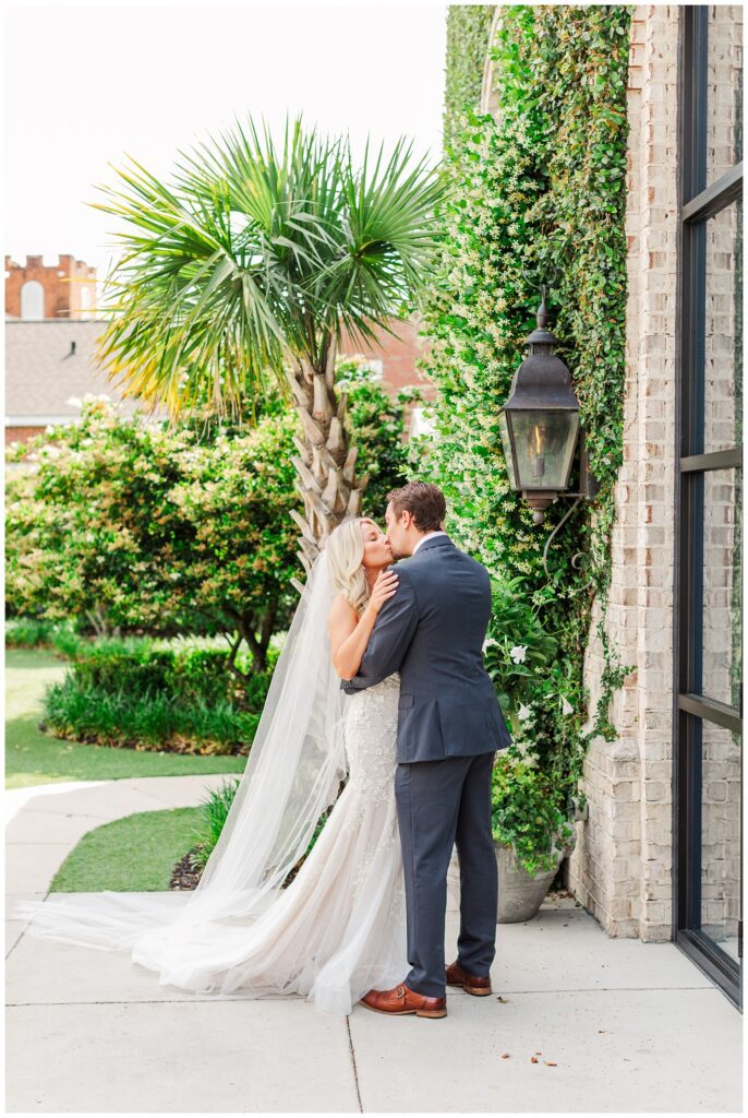 bride and groom share kiss during first look in front of a palm tree