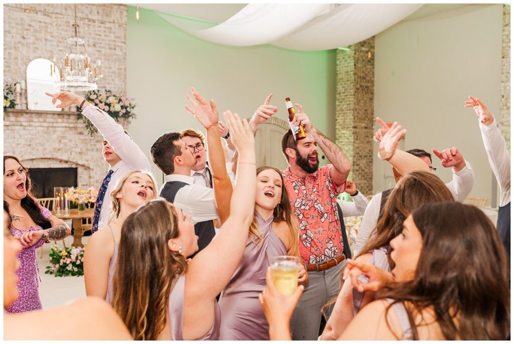 wedding guests cheering and dancing on the reception floor in Wilmington