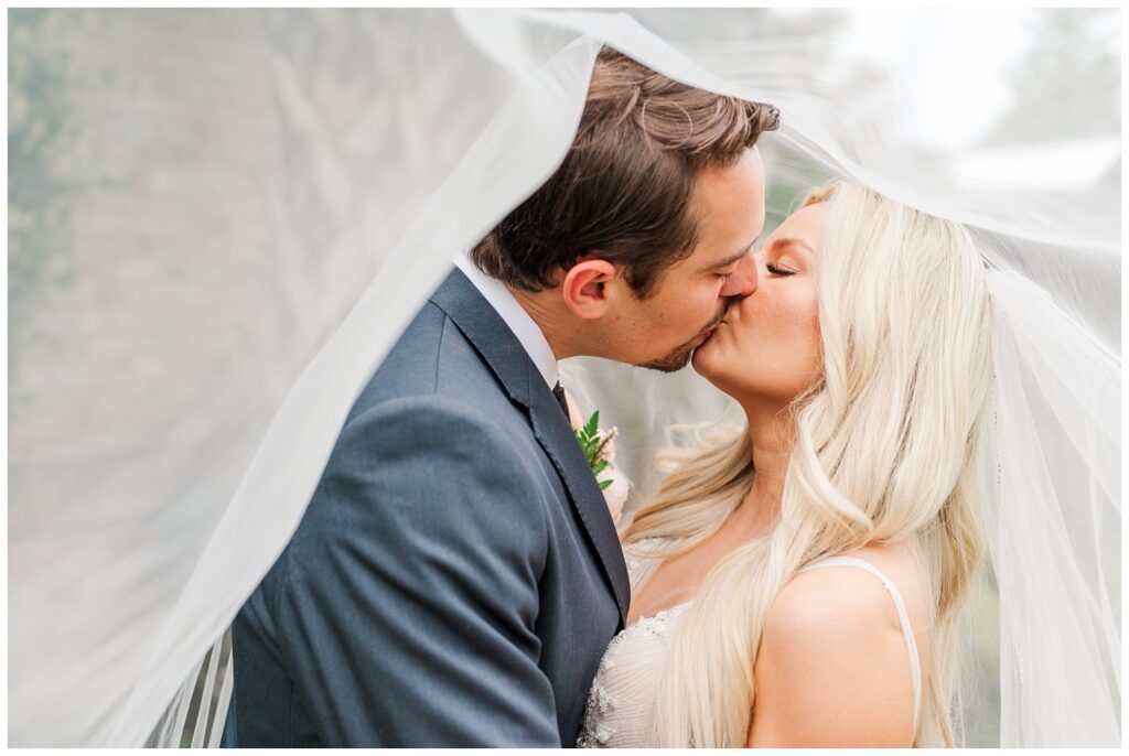 bride and groom kissing under the bride's veil at Wilmington wedding ceremony