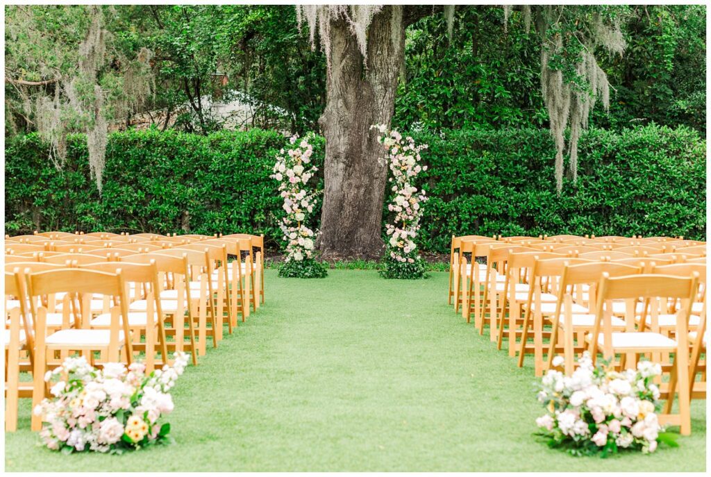 full ceremony set up outside with florals and light oak chairs in Wilmington