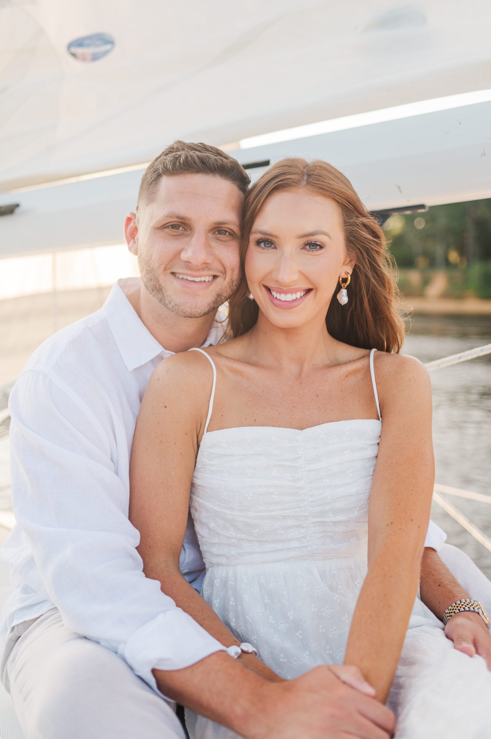 couple posing together on a sailboat near the beach