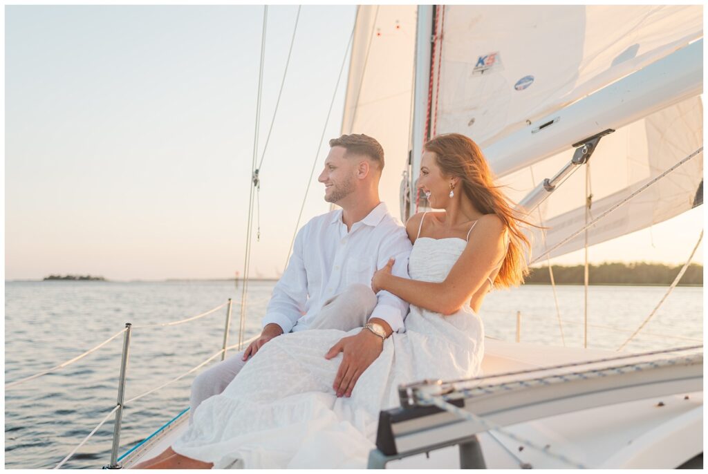 engagement couple looking out over the water during sunset in Carolina Beach