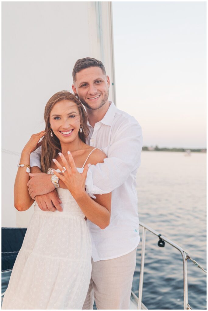 woman showing off her engagement ring at golden hour in Carolina Beach session