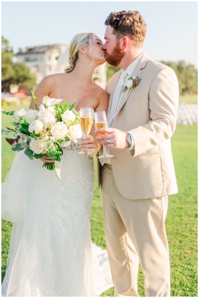 wedding couple kiss while toasting glasses of champagne