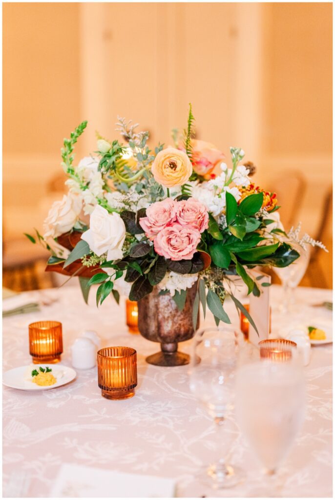 table decorated with small tealights and fresh flowers in a dark vase