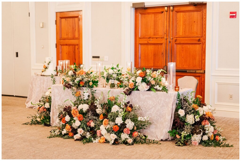 wedding couple's sweetheart table adorned with fresh flowers and candles