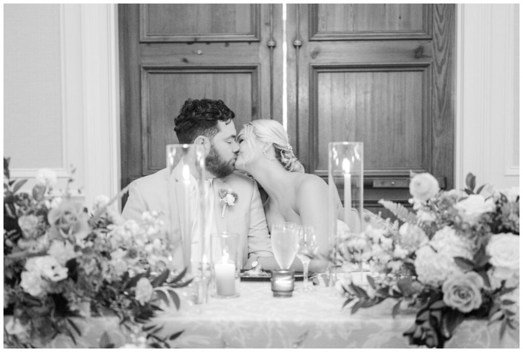 couple kisses at sweetheart table after first dance during Hilton Head reception