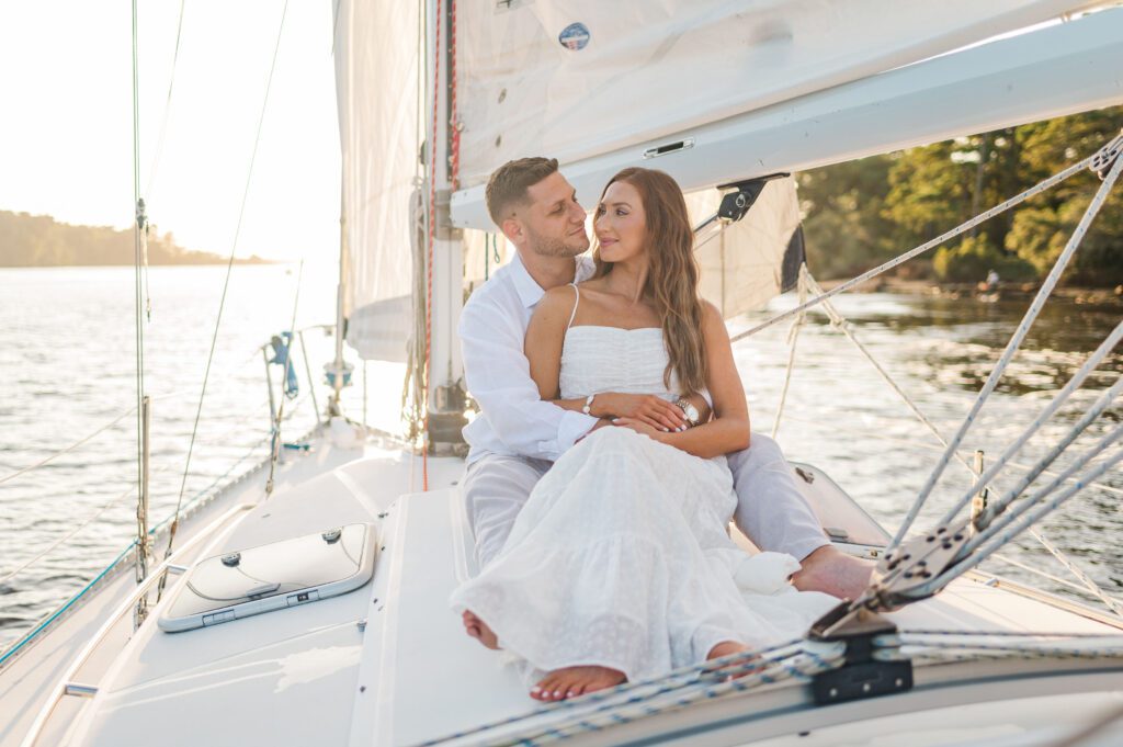 engaged couple sitting on a sailboat in Carolina Beach