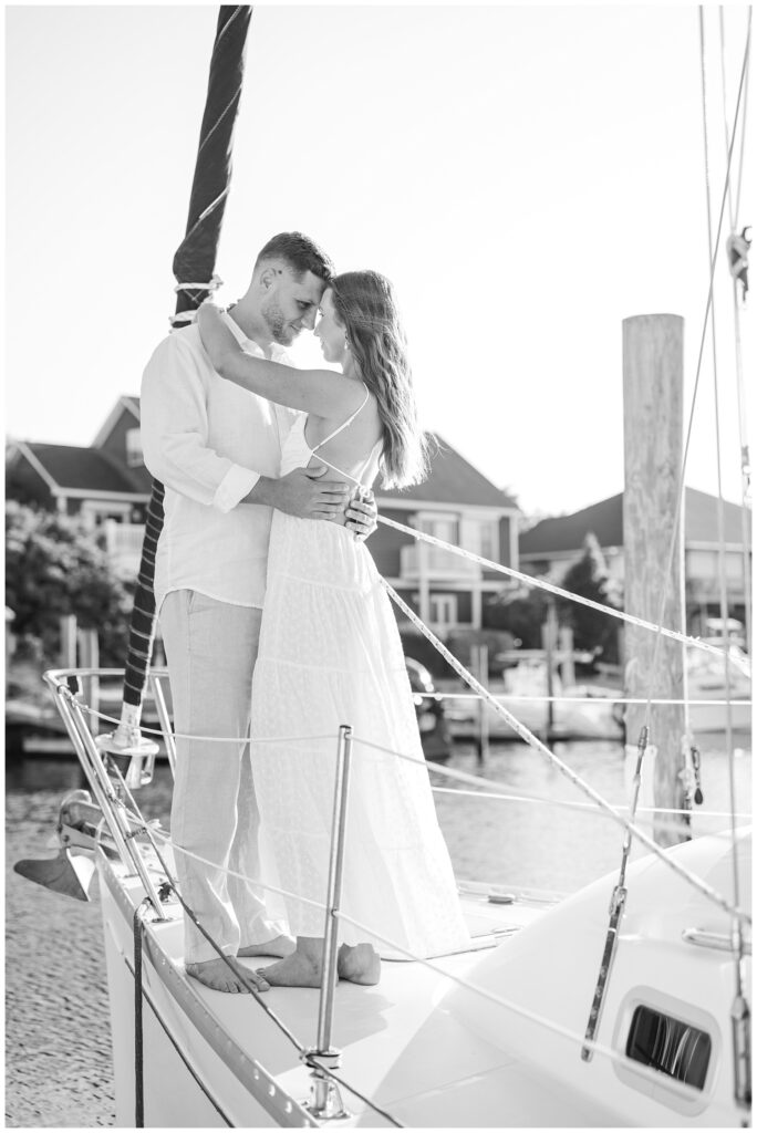 couple posing together on a sailboat for engagement portraits