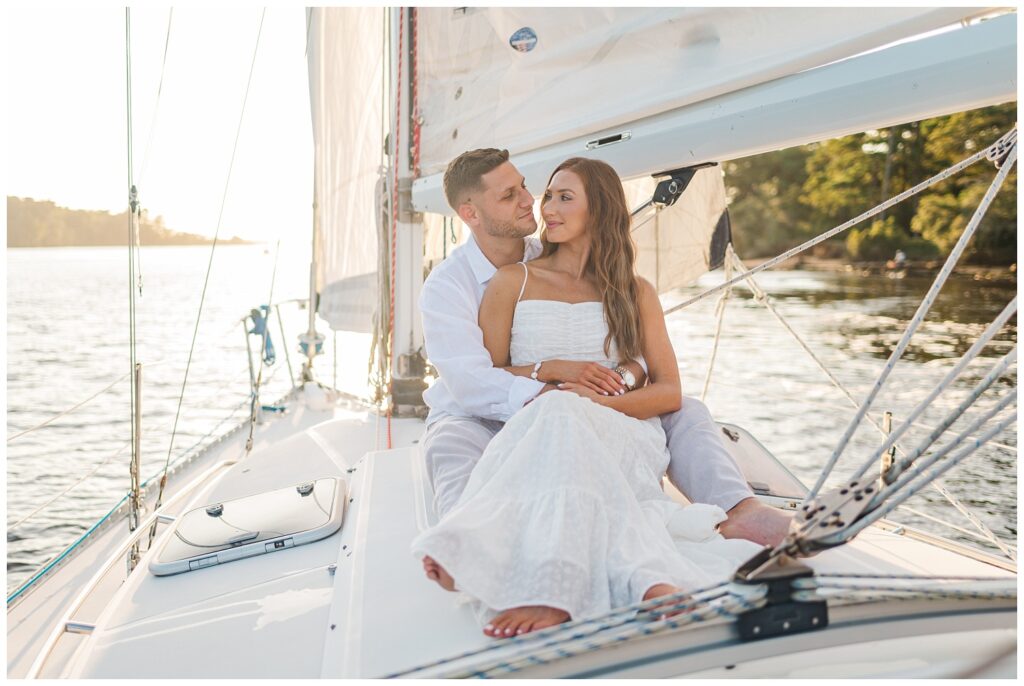 couple smiling at each other on a boat on the water for fall engagement session