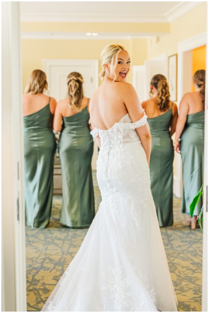 bride looking back about to surprise her bridesmaids with her dress