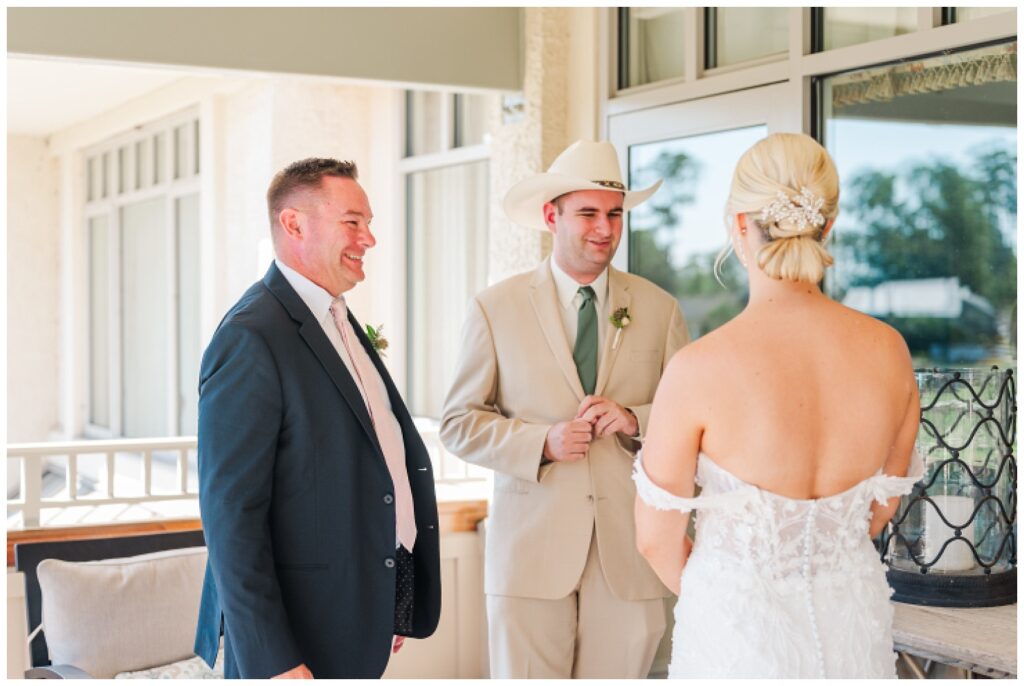 bride having a first look with her dad and brother on the balcony before wedding