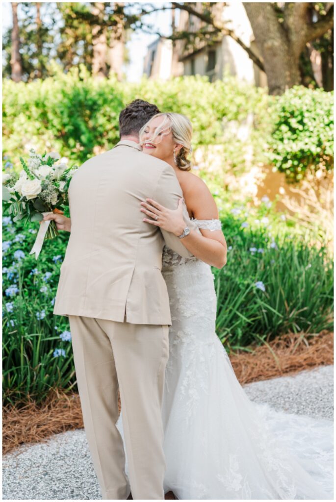 groom hugging the bride during first look while she holds her bouquet