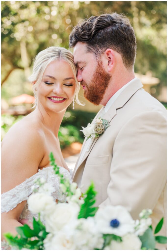 groom nuzzling the bride's temple while posing for wedding portraits 