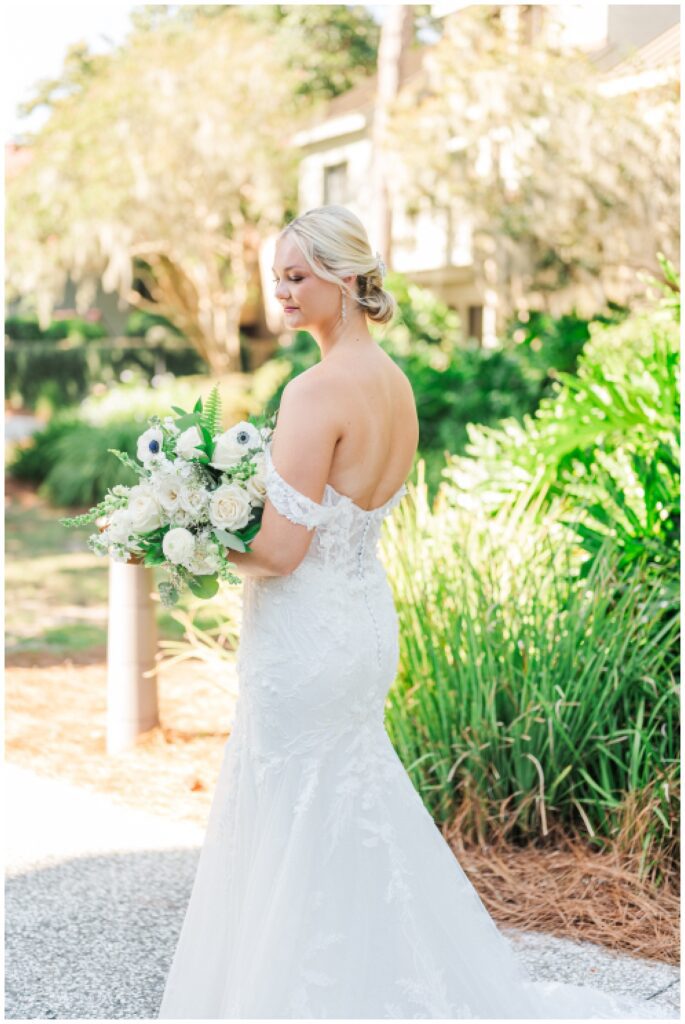 bride holding her bouquet and showing the back of her wedding dress