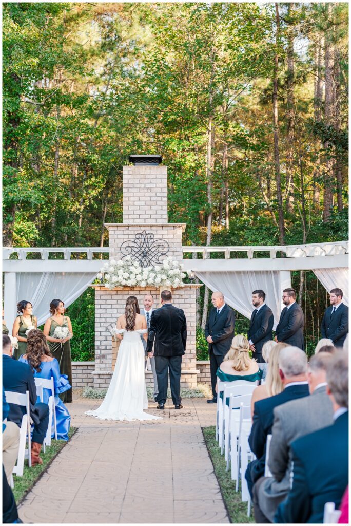 bride and groom standing at the altar holding hands for outdoor ceremony