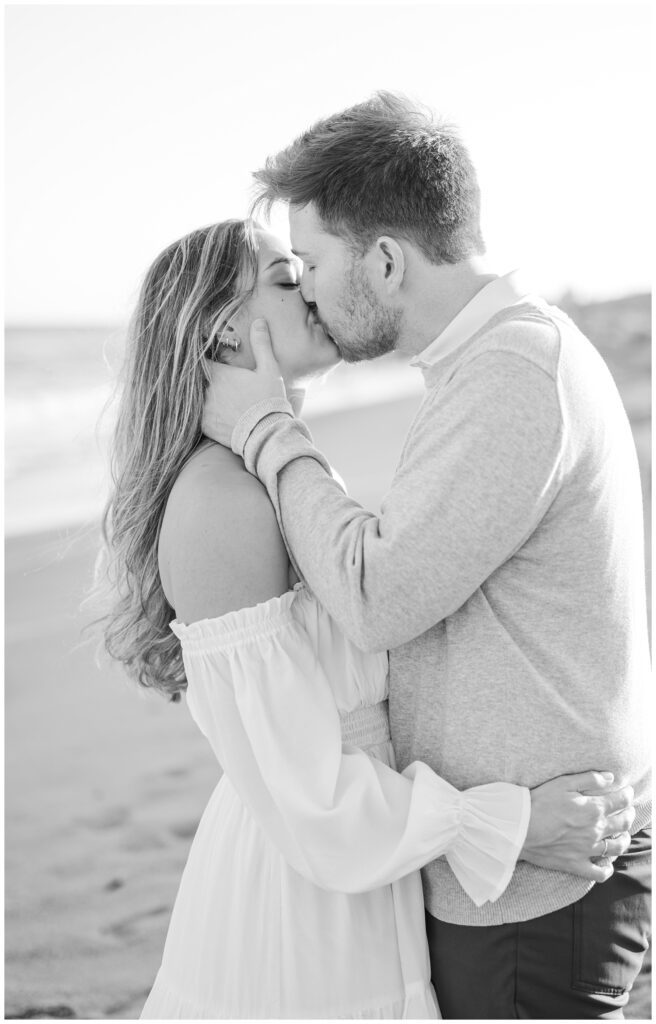 couple kissing on the beach during a golden hour engagement session in Fort Fisher