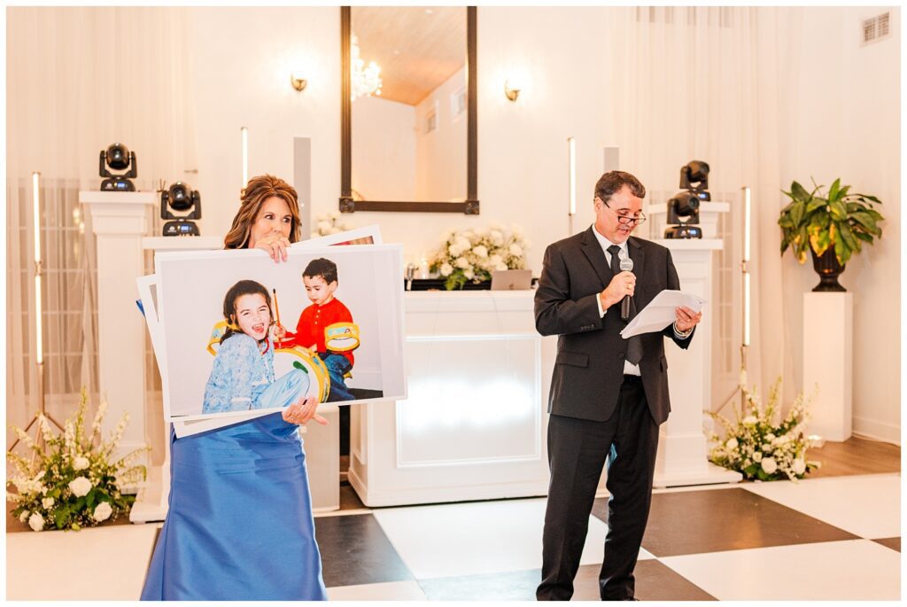 bride's mom showing large photos of the bride when she was little during speech