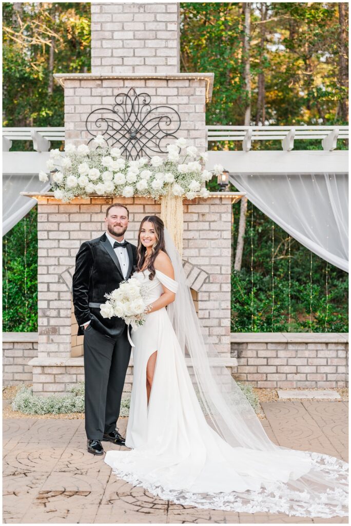 bride and groom posing at the outdoor ceremony fireplace site after wedding