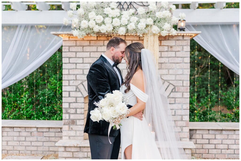 bride and groom posing at the outdoor ceremony fireplace site after wedding