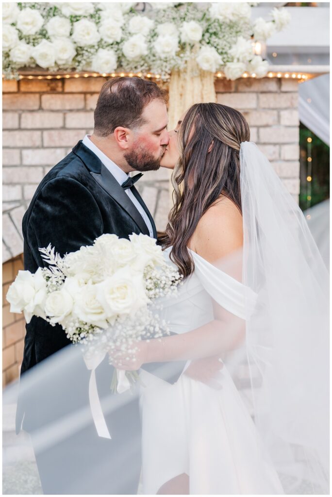 wedding couple kissing after ceremony in front of outdoor fireplace altar