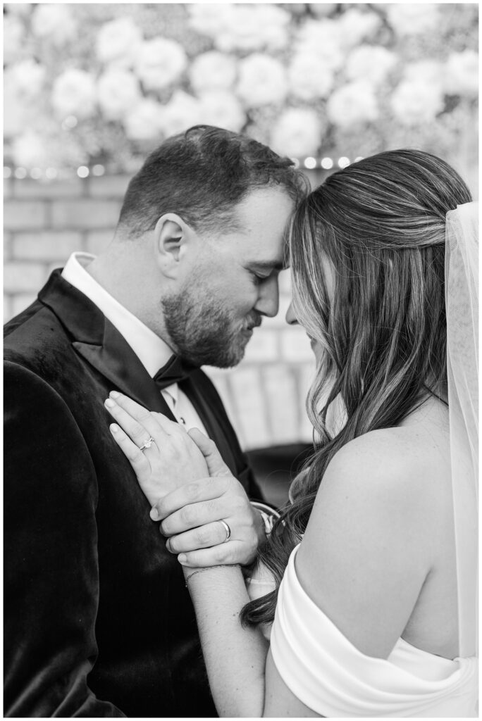 wedding couple touching foreheads and holding hands after the ceremony