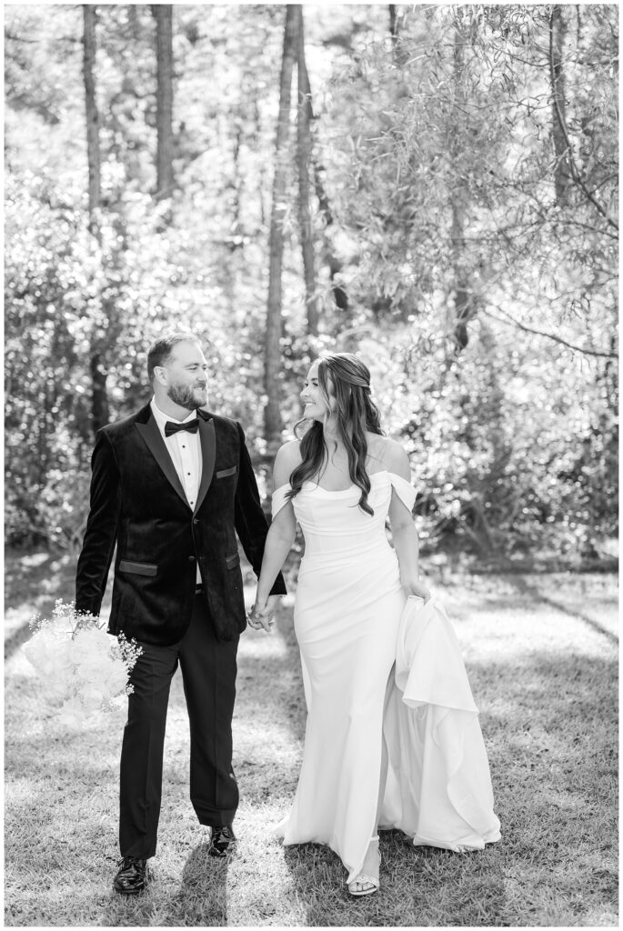 couple walking together while the groom holds the bouquet at wedding 