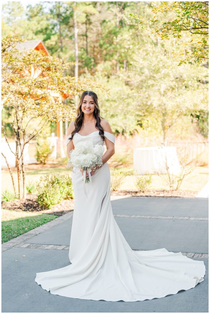 bride posing for portraits on the patio while holding her bouquet at Malachi Meadows