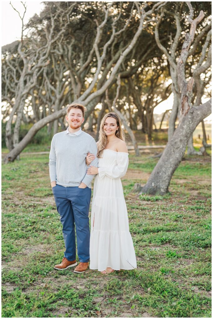 engagement couple posing together in front of live oaks at Fort Fisher