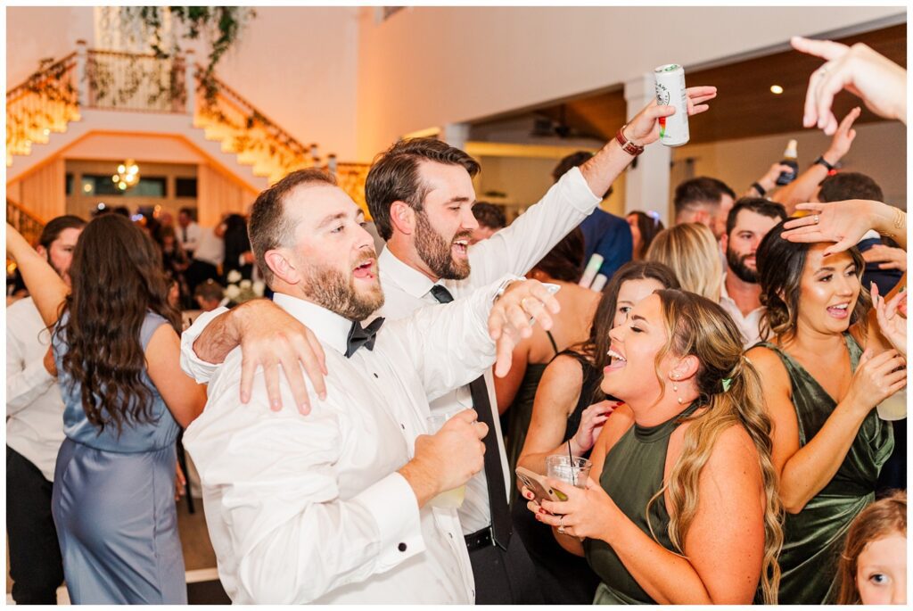 wedding guests drinking and dancing with the groom at fall reception in Currie, NC