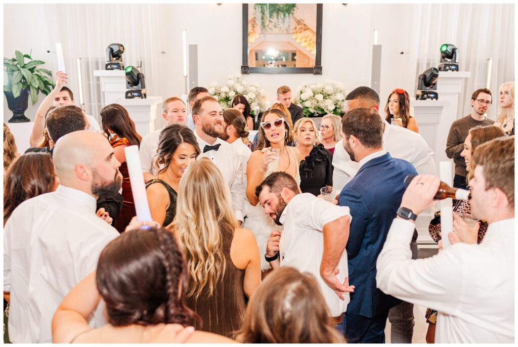 bride wearing a short party dress and heart sunglasses on the dance floor with her friends