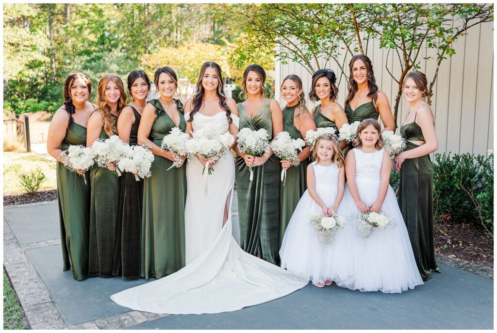 bridal party posing on the patio next to the wedding venue outside 