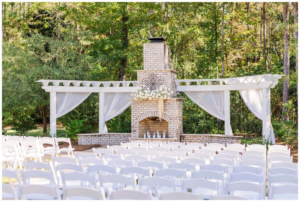 full ceremony site with white flowers and chairs outside at Malachi Meadows venue