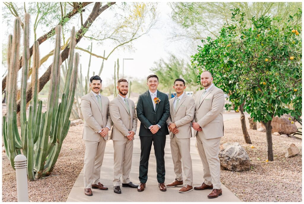 groomsmen posing with hands in front on the sidewalk at the Gold Canyon Golf Resort