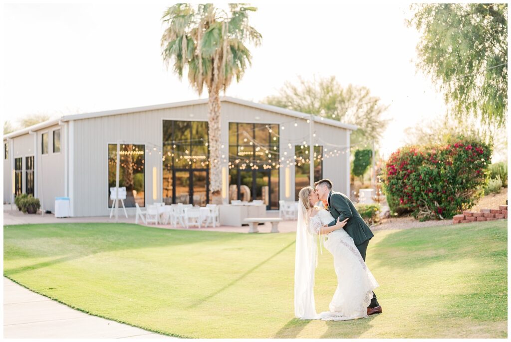 groom dipping the bride back for a kiss on the front lawn of the Gold Canyon, AZ venue