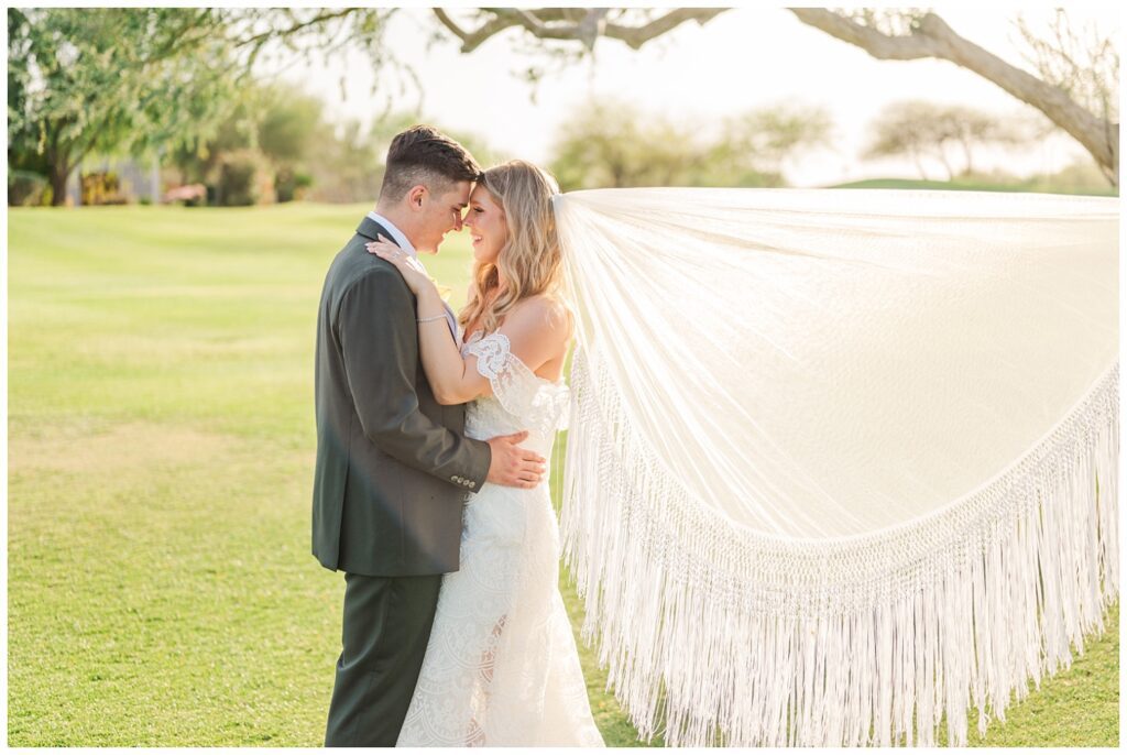 groom and bride touching foreheads with bride's fringe veil fluffed behind her