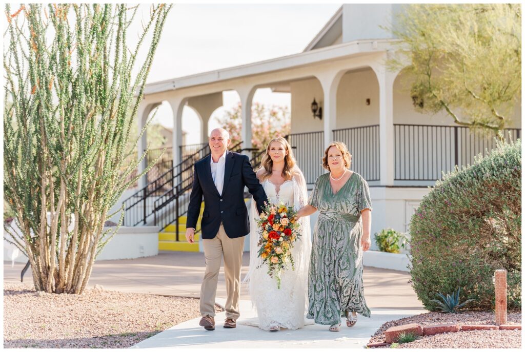 bride being walked down the aisle by her parents at Arizona destination spring wedding 