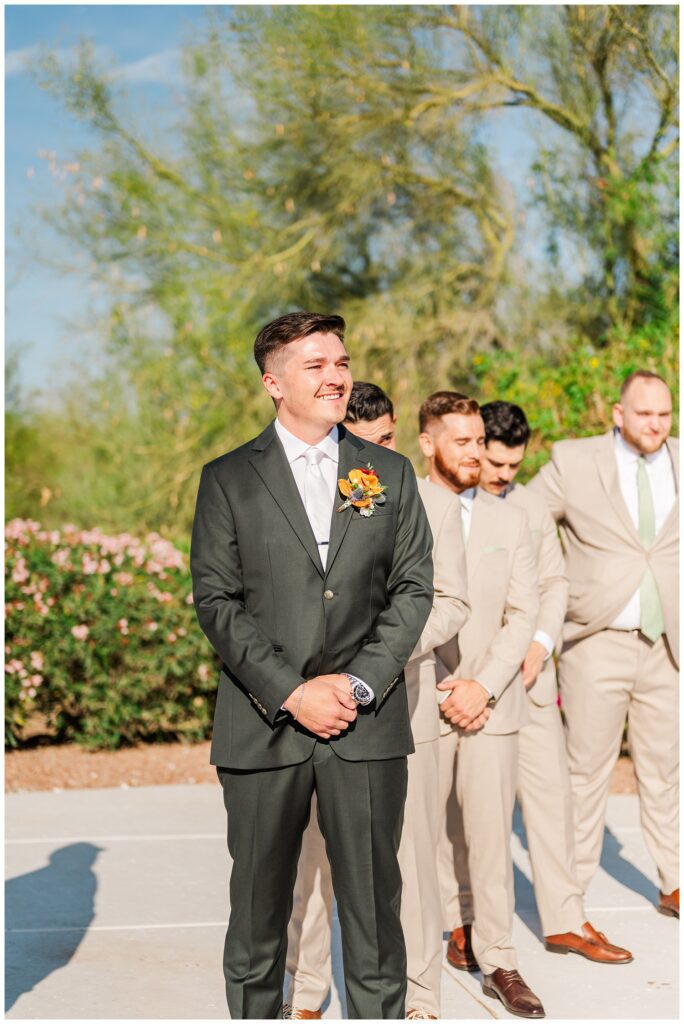 groom watching the bride being walked down the aisle by her parents at Arizona destination spring wedding 