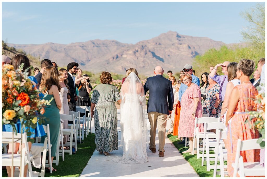 bride being walked down the aisle by her parents at Arizona destination spring wedding 