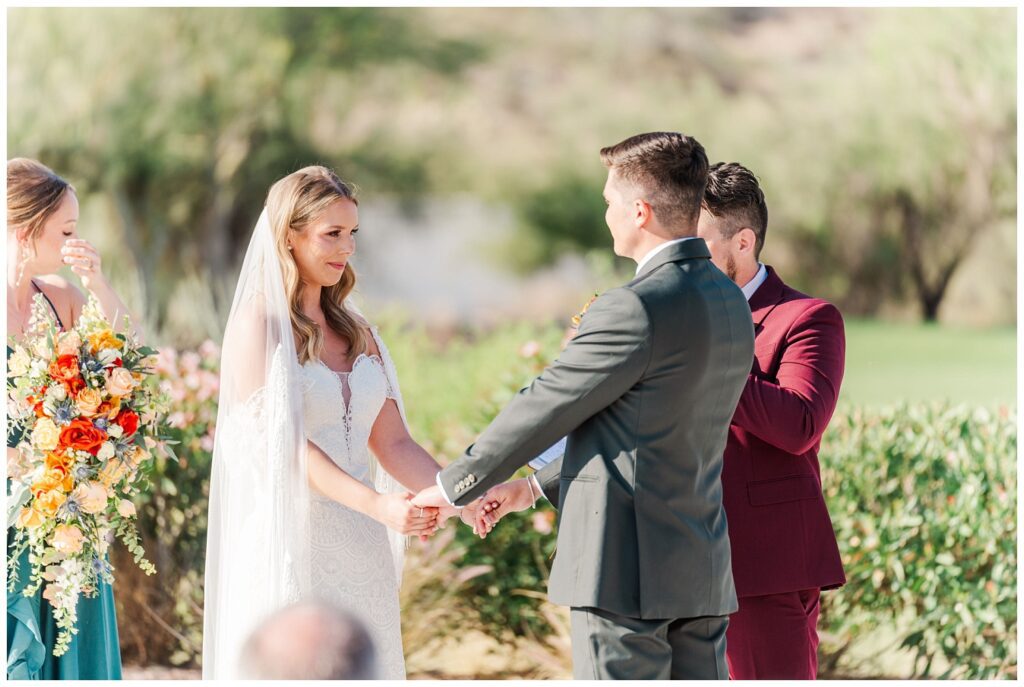 bride and groom smiling at each other and holding hands during the ceremony in Arizona