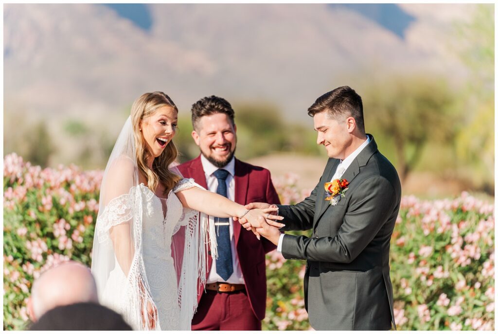 groom showing off the bride's ring to the wedding guests during the ceremony outside in Arizona